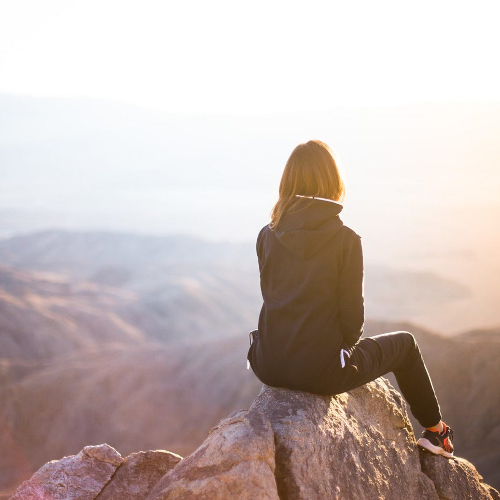A woman seated on a mountain top
