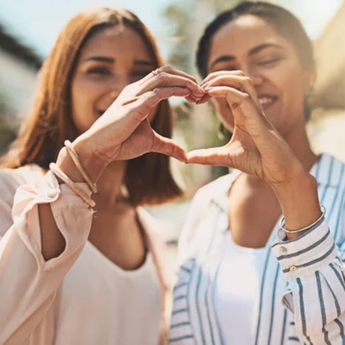 Two women making a heart with their hands